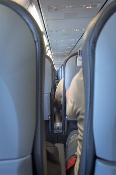 Interior of passenger airplane with people on seats.