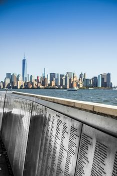 Name of immigrants on steel panels at Ellis Island New York skyline