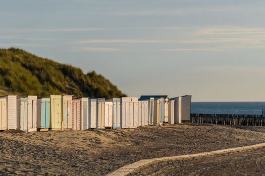 Colorful sheds at the beach in front dunes sunset