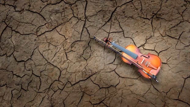 Top view Violin over texture of grunge dry cracking parched earth