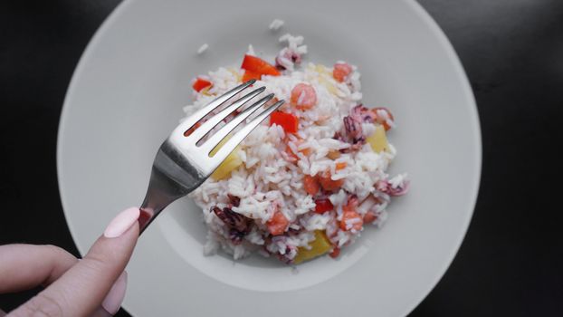 Rice with with shrimp and pineapple, thai or china food on white dish. Fork in hand