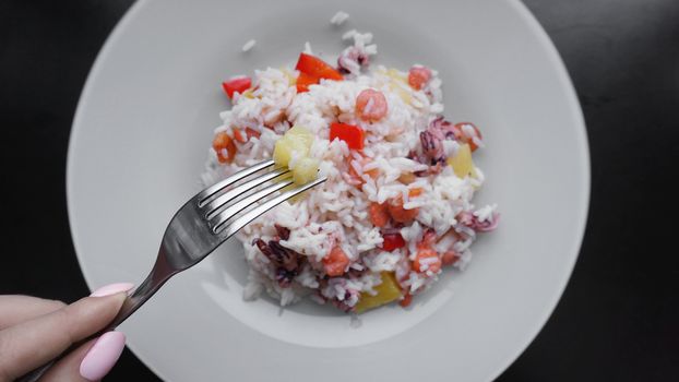 Rice with with shrimp and pineapple, thai or china food on white dish. Fork in hand