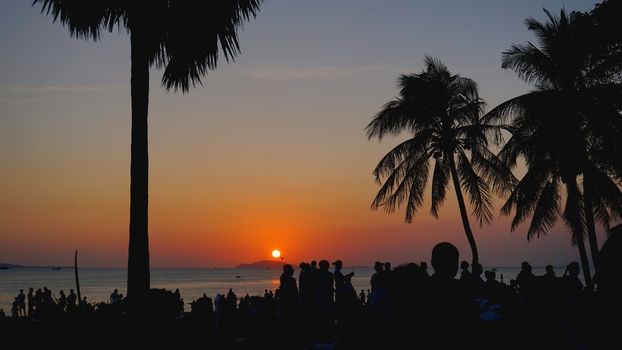 Silhouetted People Relaxing on Sunset Beach. Travel concept