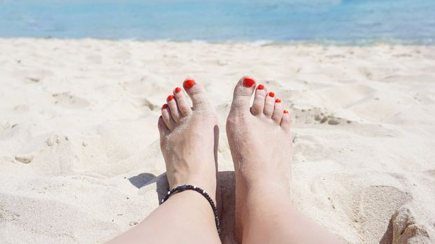Close up of legs. Woman relaxing in sea while spending summer day at the beach.