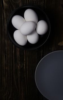 Chicken eggs in plate on a wooden table