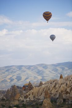 Hot air balloons flying over the rocky land. Cappadocia, Turkey