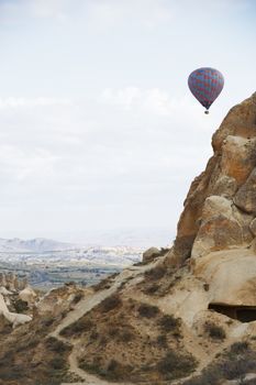 Hot air balloon flying over the rocky land. Cappadocia, Turkey