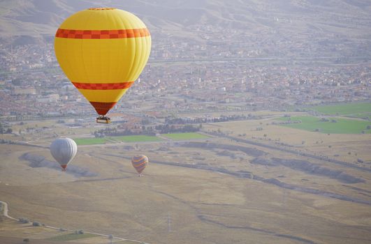 Three air balloons flying over the land. Front view