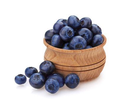 Blueberry isolated on white background. A pile of fresh blueberries in a wooden bowl, fresh wild berries, ideal for use in packaging, close-up