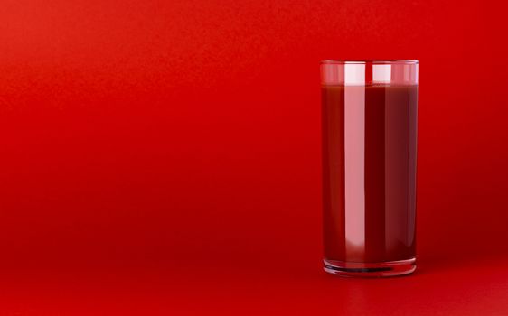 Glass of tomato juice isolated on red background with copy space. Fresh tomatoes juice, bloody Mary cocktail, close-up