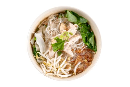 Asian rice noodles soup with vegetables and chicken in bowl. Top view flat lay isolated on white background.