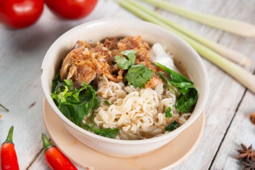 Asian ramen noodles soup and chicken in bowl.