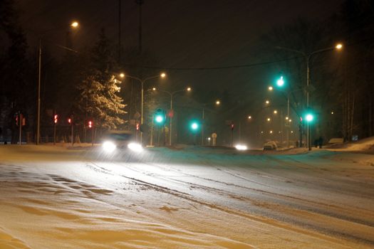 Snowy winter road with cars driving on roadway in snow storm