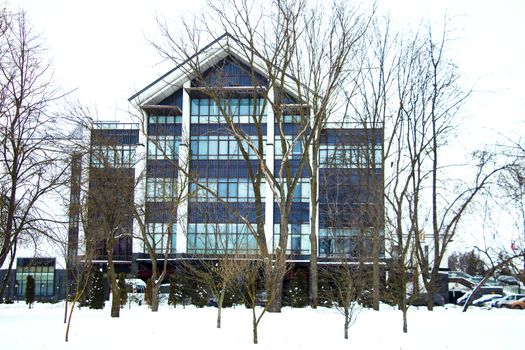 Modern rounded cottage with iron gates at frosty and sunny winter day