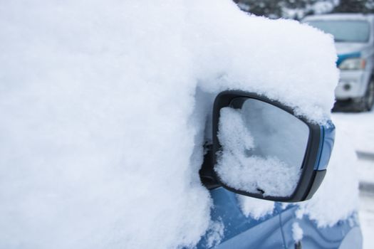 Closeup of a car covered in snow