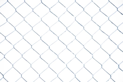 Wire fence in the snow. Fence background. Metallic net with snow. Metal net in winter covered with snow. Wire fence closeup. Steel wire mesh fence vintage effect