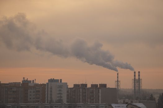 Smoking pipes from heating plants that supply heat to the city and the sky in the winter morning
