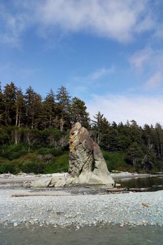 Tall rocks reflecting on water on the beach