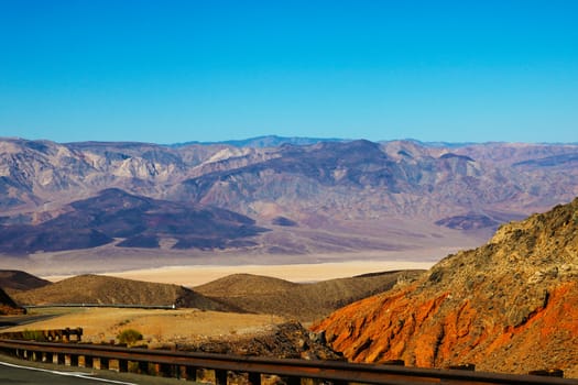 Winding road in Death Valley. Dry clay soil and a cloudless sky