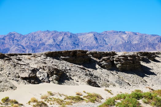 Parched river bed on the background of mountains and sky