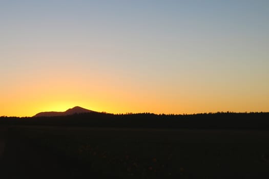 Scenic View Of Silhouette Mountains Against Orange Sky