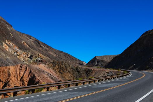 Classic panorama view of an endless straight road running through the barren scenery of the American Southwest