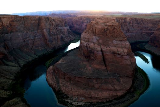 Sunset over famous Horseshoe Bend Utah and Arizona. The beautiful Colorado river carved this horseshoe shaped sandstone reflecting orange, red, green and purple of nature s wonders