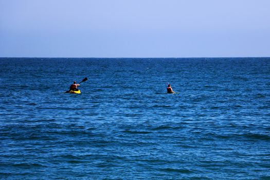 A couple of friends canoeing on a wooden canoe on a sunny day. USA