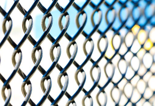 Metal fence on a white-blue background.