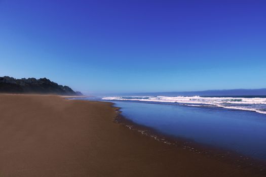 Coast of Pacific Ocean on a sunny day with a beautiful sky.