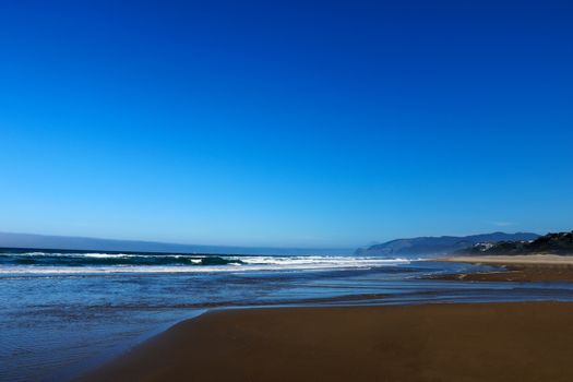 The beach on the Pacific Ocean on a sunny day with a beautiful sky.