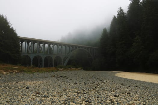 Old bridge in misty morning on the Pacific coast.