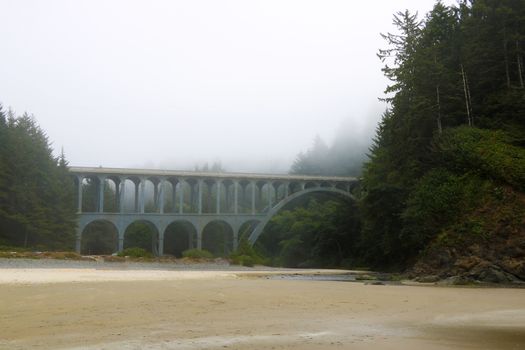 Old bridge in the fog on the coast of the Pacific Ocean.