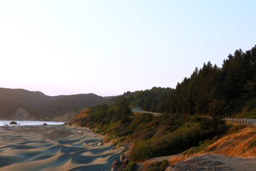 The road along the sandy beach of the Pacific Coast during sunset.