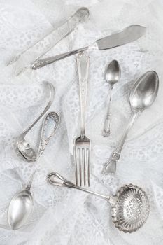 Silverware on a white guipure fabric closeup