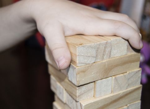 Detail of wooden block and sticks in baby's hands, the concept of teaching and education of young children