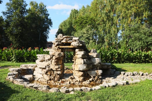 Beautiful man-made falls from a stone made the person in a garden.