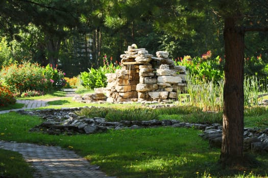 Beautiful man-made falls from a stone made the person in a garden.