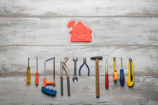 Set of work tool on gray wooden background with icon of house in space, industry engineer tool concept.still-life.