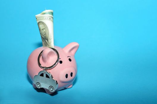 Pink piggy bank with a car on the table. Tinted. Concept of saving finances and contributions to property