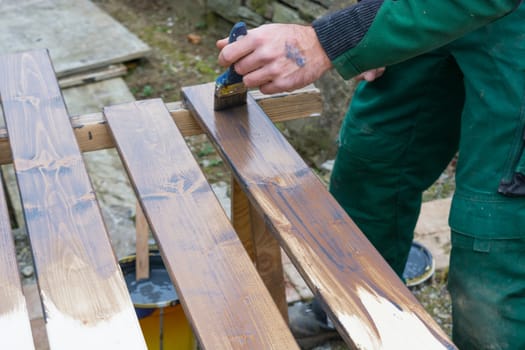 Half painted wooden surface. Brown colour. Paint natural wood with a brush
