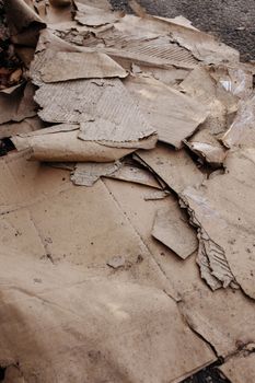 Dumped, dirty and ripped corrugated cardboard on a pavement; fly-tipping