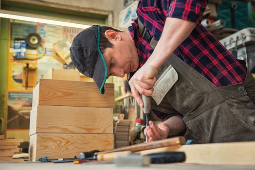 Carpenter worker cutting wooden board with circular saw. Profession, carpentry and woodwork concept.