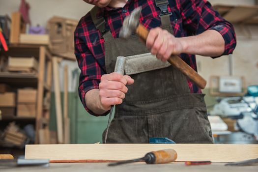 Carpenter worker cutting wooden board with circular saw. Profession, carpentry and woodwork concept.