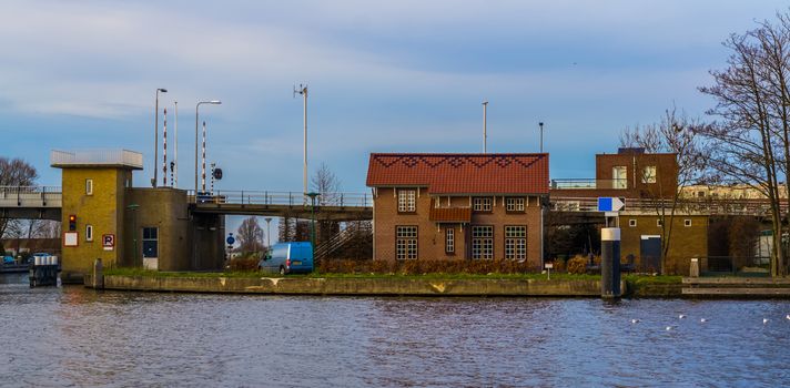 Dutch bungalow at the water side, with view on the molenaarsbrug, city architecture of Alpehn aan den Rijn, The netherlands