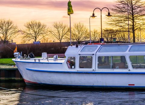 Docked boat in the harbor at sunset, colorful sky at dawn, water transportation vehicle
