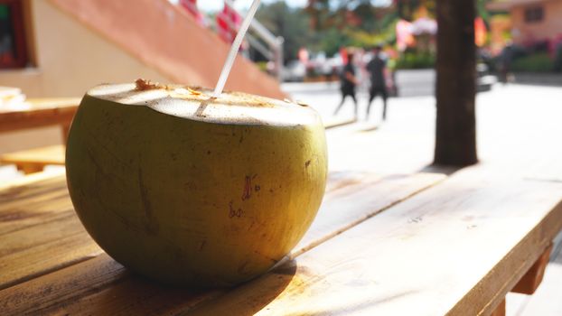 Coconut Water Drink on table with blurry background. Beach cafe, travel and relax