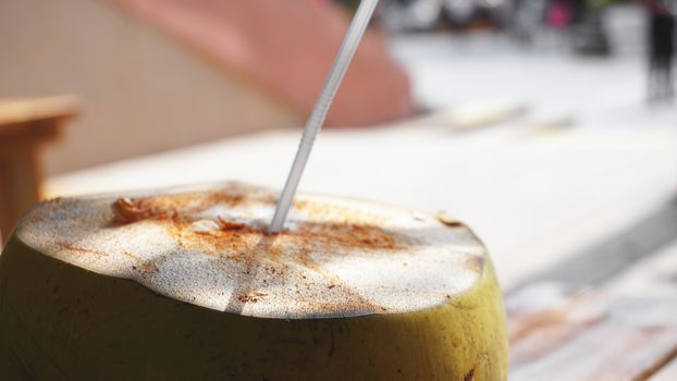 Coconut Water Drink on table with blurry background. Beach cafe, travel and relax