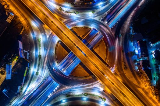 Aerial view of traffic in roundabout and highway at night.