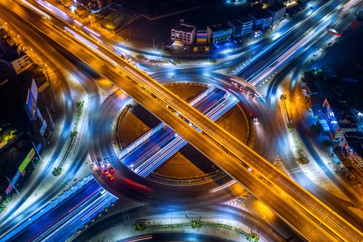 Aerial view of traffic in roundabout and highway at night.